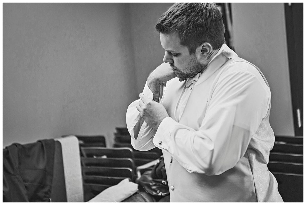 groom fixing his cuff links