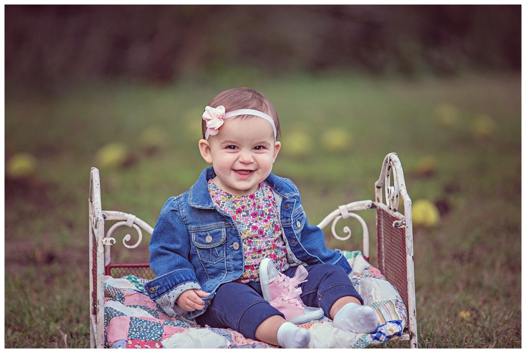 nine month girl sitting on vintage bed