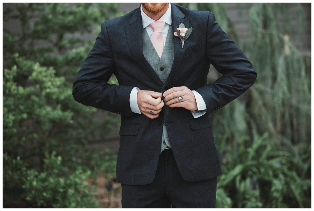 close up of groom fixing his tux