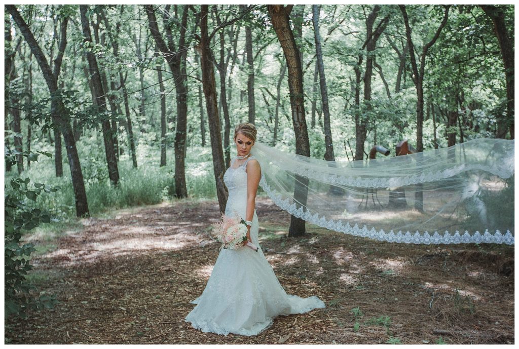 bride with long vail in the woods