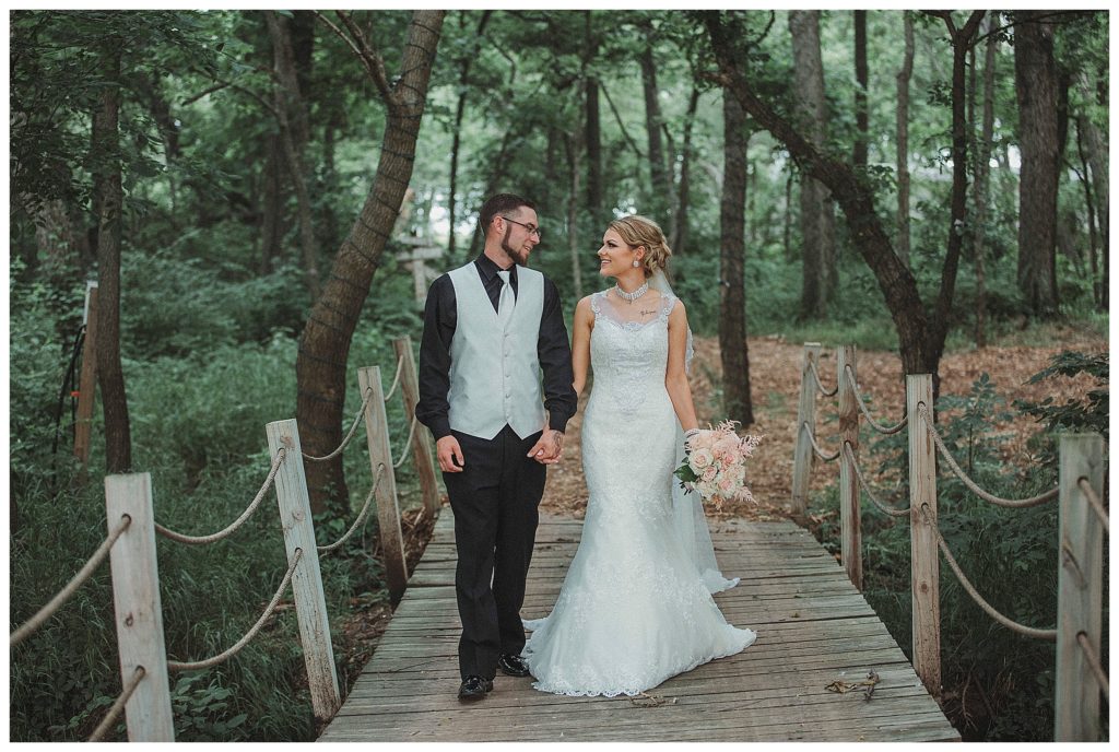 bride and groom walking on bridge