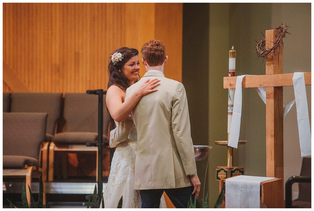 bride and groom praying at the cross