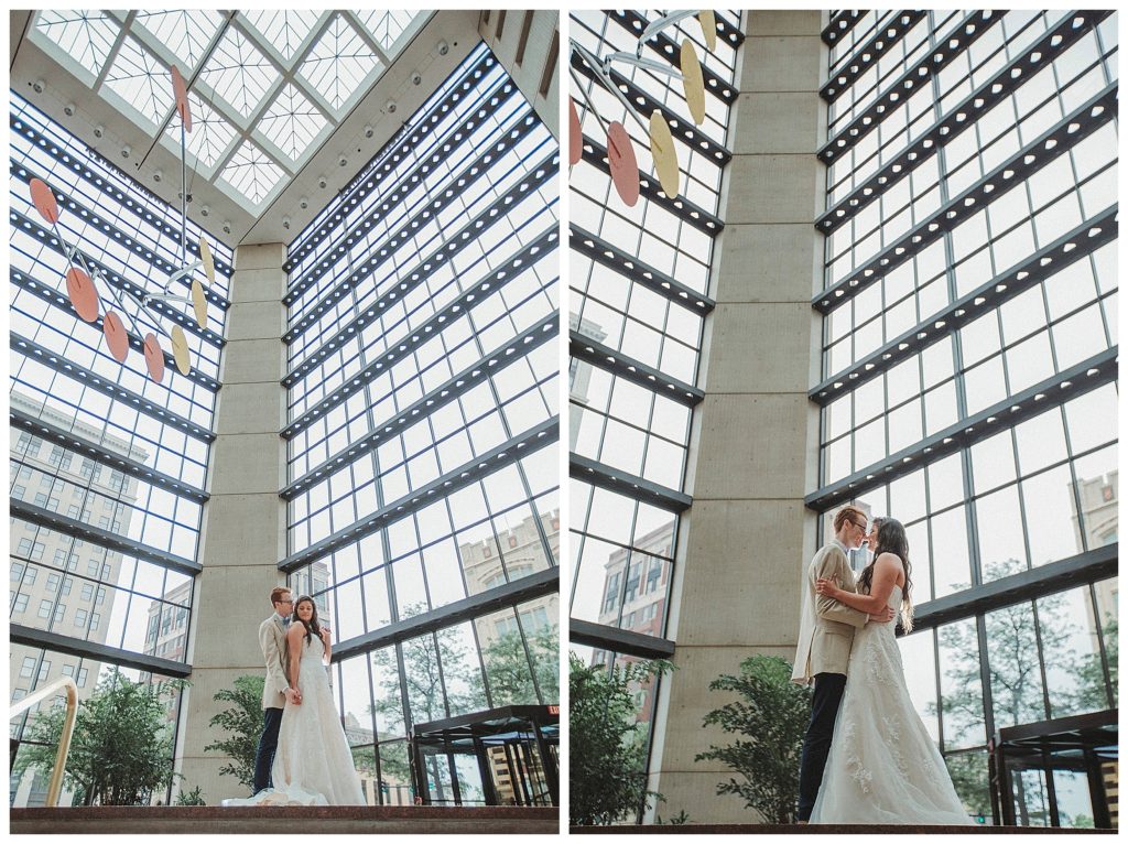 bride and groom in front of large windows