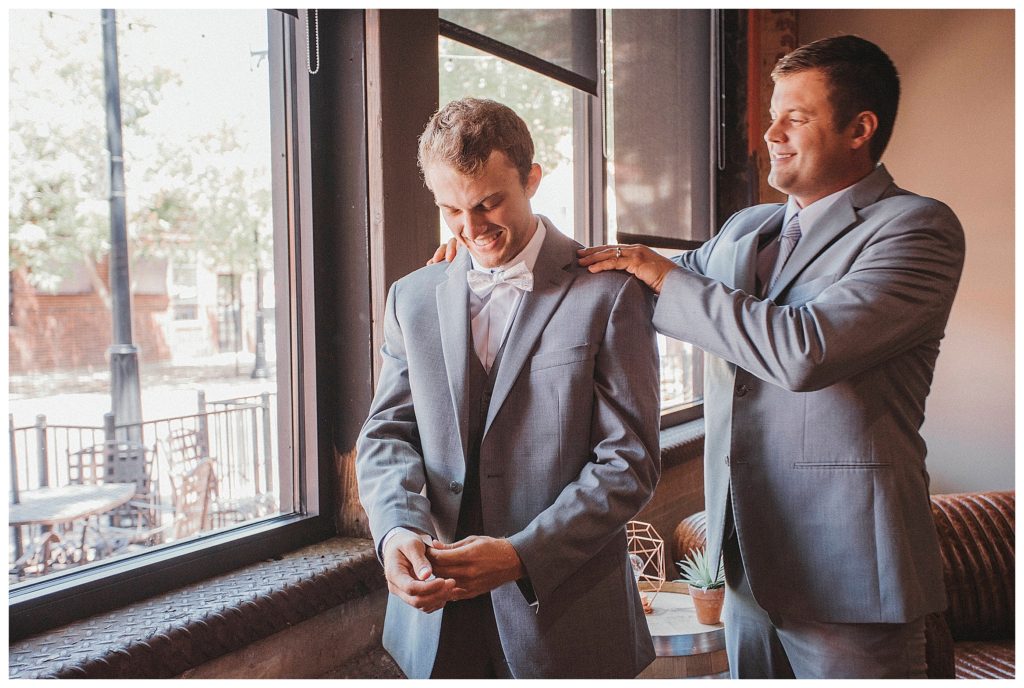 groomsmen helping groom get ready