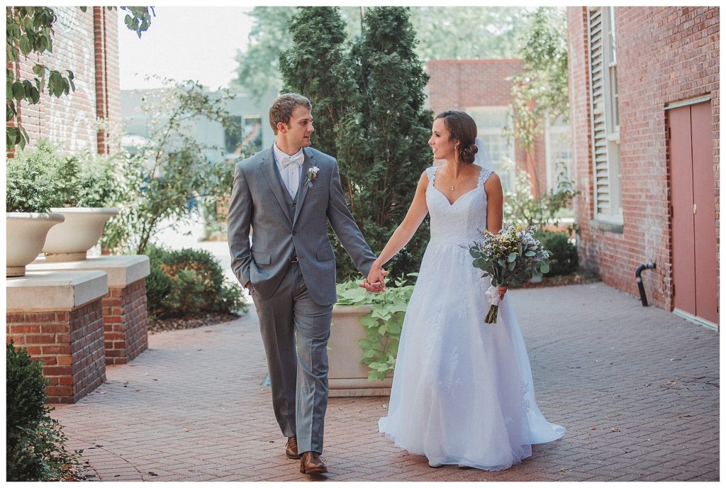 bride and groom walking in courtyard