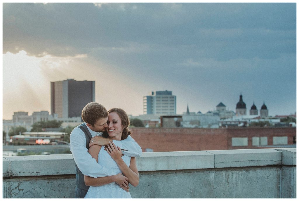 bride and groom on top of parking garage at sunset