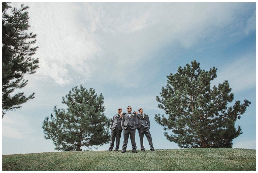 groom and his groomsmen posing on top of hill