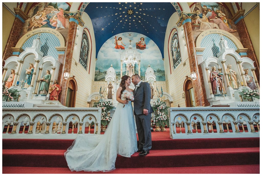 bride and groom posing at the alter