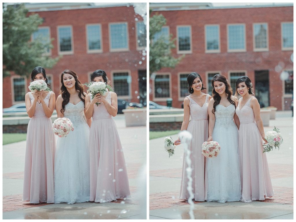 bride with her bridesmaids standing by fountain