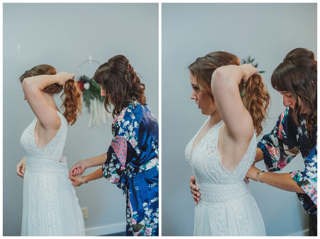 brides mother helping her in wedding dress