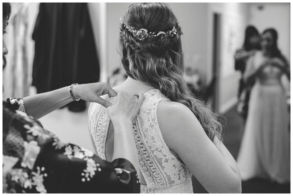 bride getting her dress buttoned