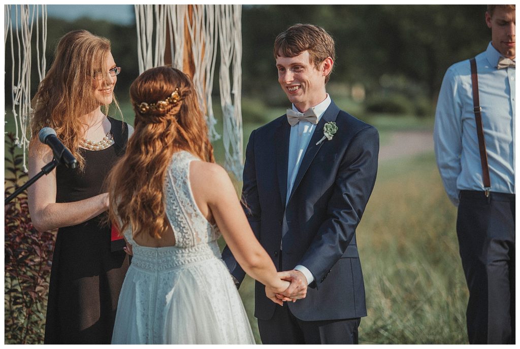 groom smiling at bride at the alter