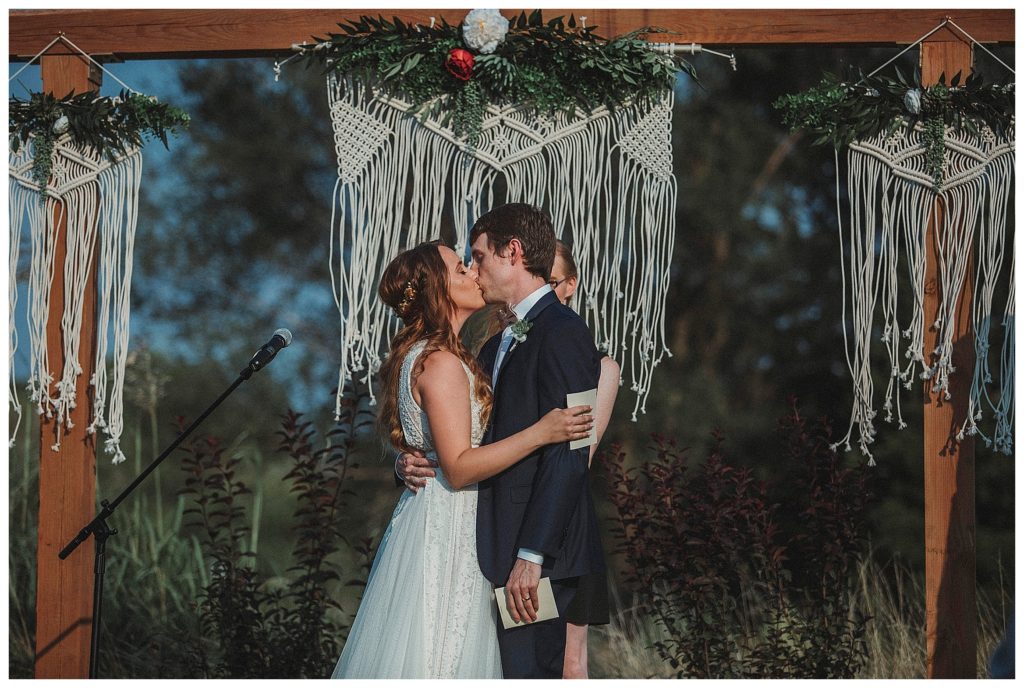 bride and groom kissing at alter