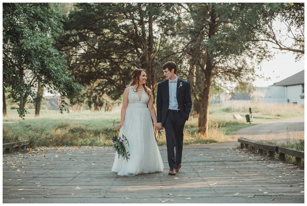 bride and groom walking along bridge