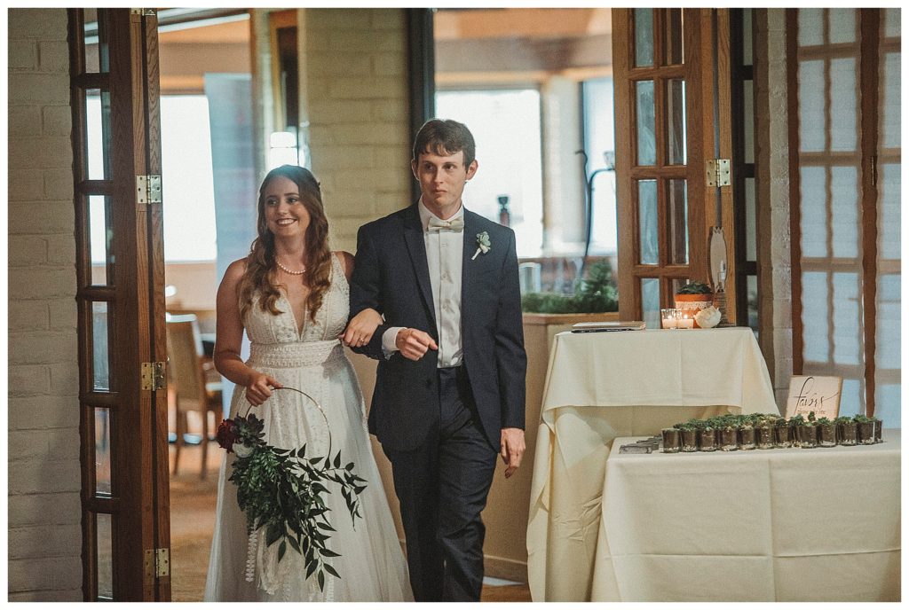 bride and groom walking into reception