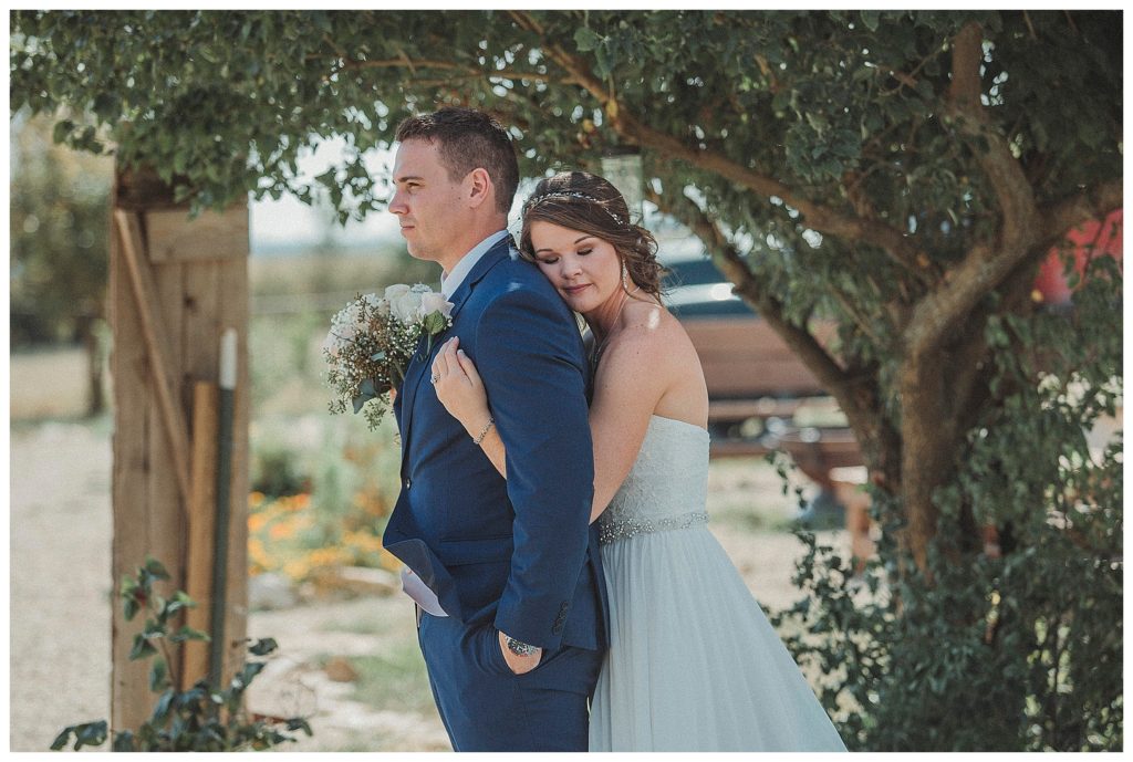 bride hugging groom from behind