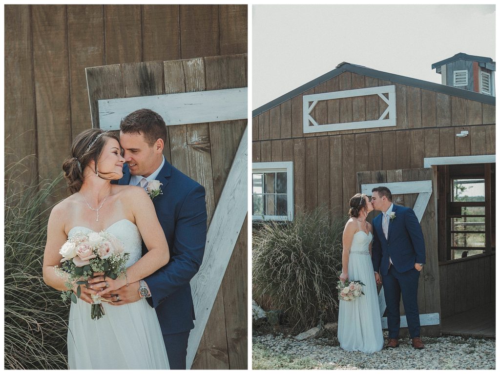 bride and groom standing in front of barn