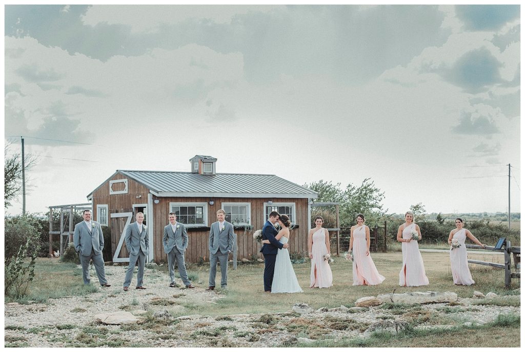 bridal party standing in front of barn