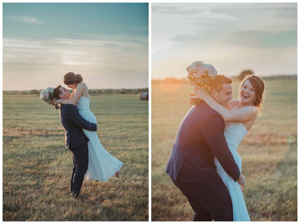 groom holding his bride at sunset