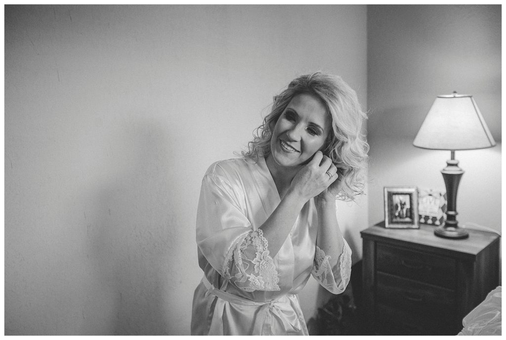 bride putting her earrings on