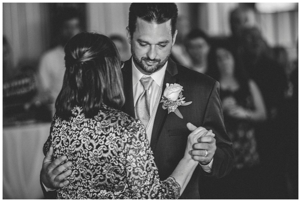 groom dancing with mom in barn