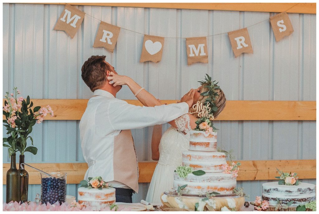 bride and groom smashing cake in faces