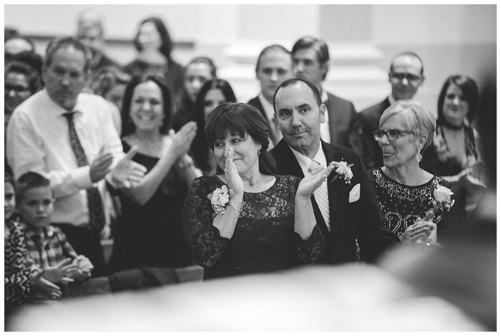 brides parents clapping after the kiss