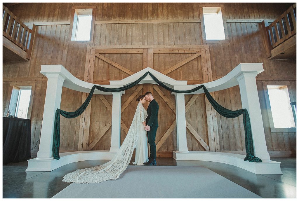 bride and groom under the arbor