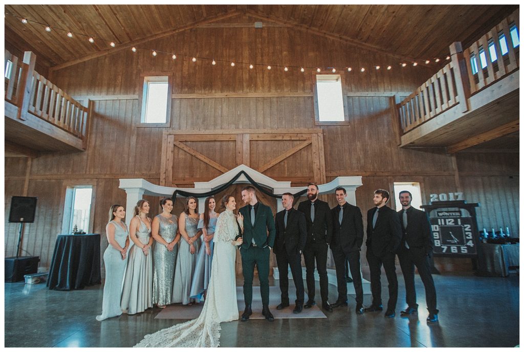 bridal party standing together in the barn