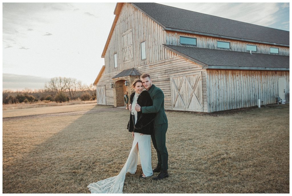 bride and groom in front of barn