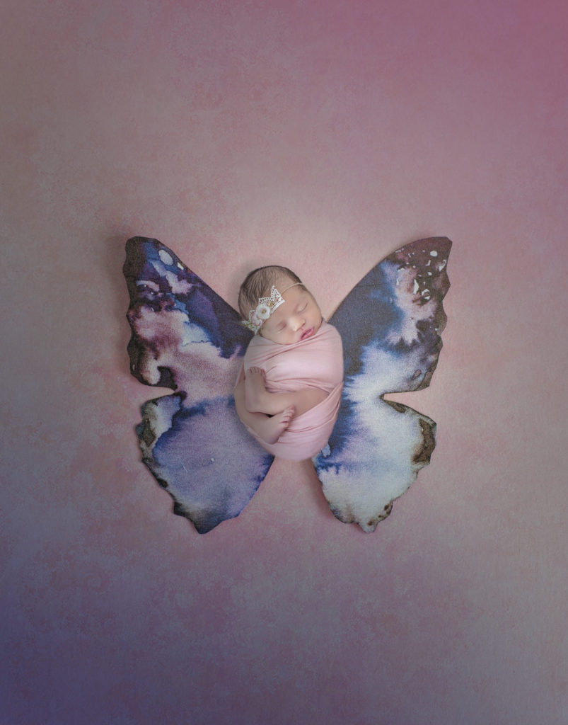 newborn girl on purple butterfly wings