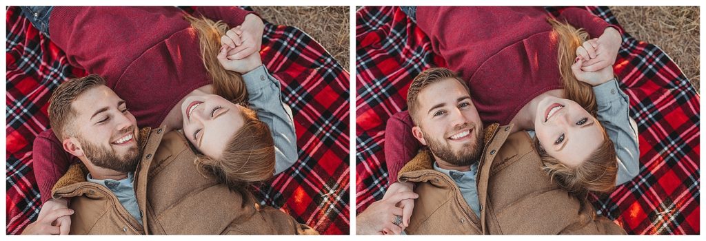 couple laying down on plaid blanket