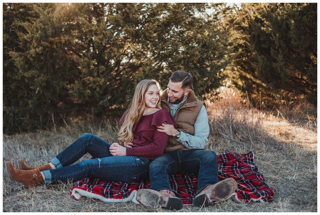 couple sitting on plaid blanket