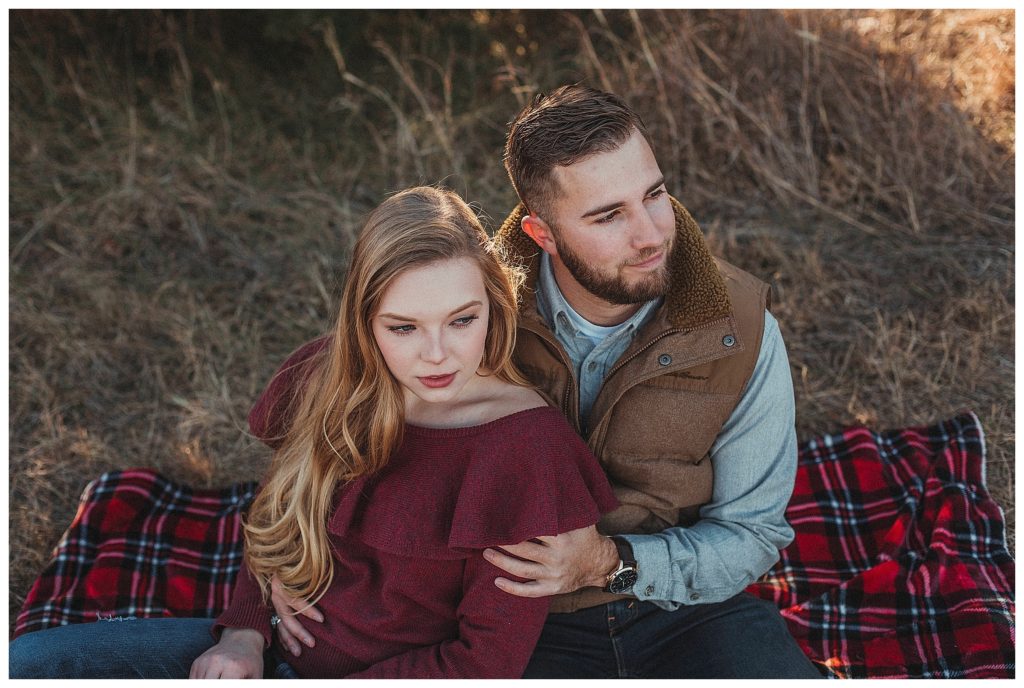 couple sitting on plaid blanket