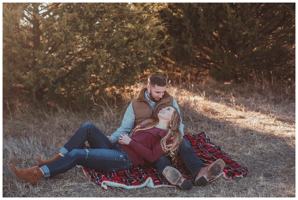 couple sitting on plaid blanket